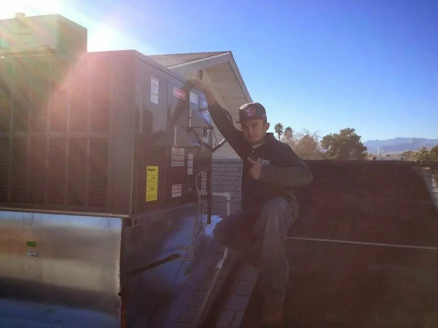 HVAC technician performing AC Tune-Up on a rooftop unit in Bloomingdale