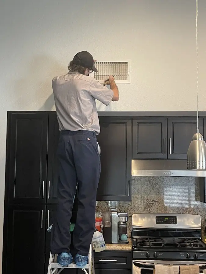 Technician inspecting an air vent during HVAC service in Bloomingdale